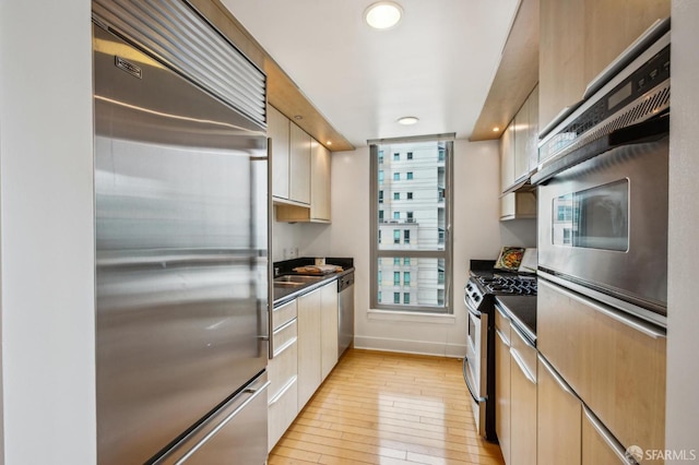 kitchen featuring appliances with stainless steel finishes and light hardwood / wood-style floors