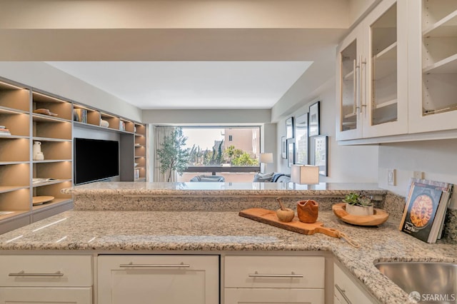 1177 California St Unit 212, San Francisco, CA 94108 - kitchen featuring light stone counters, healthy amount of natural light, and white cabinets