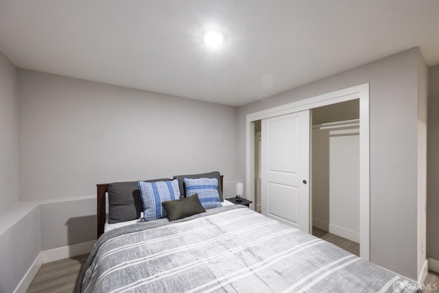 bedroom featuring a closet, baseboards, and wood finished floors