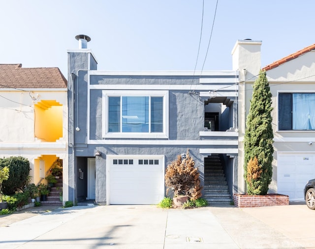 view of front of property with a garage, stairs, concrete driveway, and stucco siding