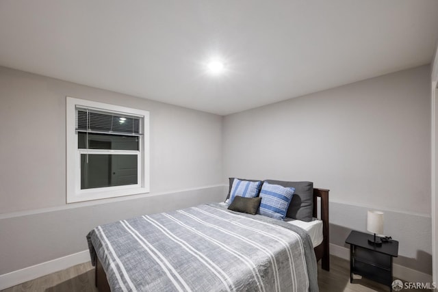 bedroom featuring baseboards and wood finished floors