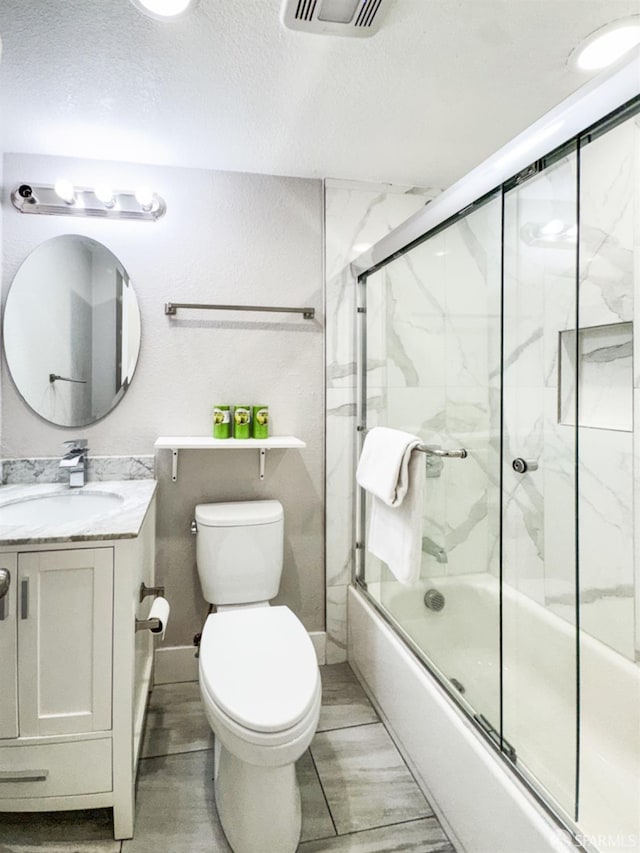 full bath featuring enclosed tub / shower combo, toilet, visible vents, vanity, and wood tiled floor