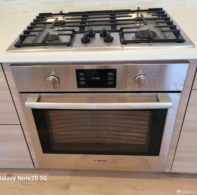 room details featuring appliances with stainless steel finishes and decorative backsplash