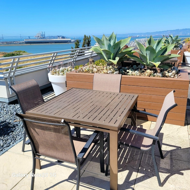 view of patio featuring a balcony and a water view