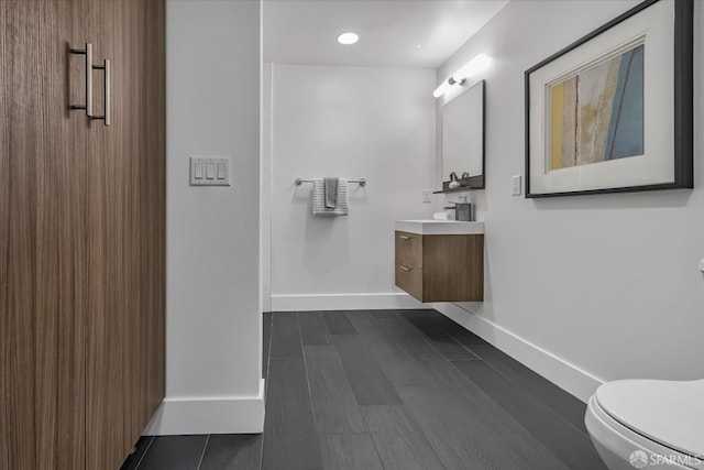 bathroom featuring wood-type flooring, vanity, and toilet