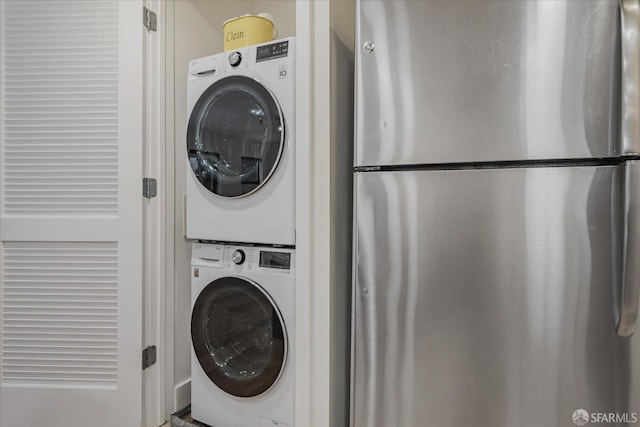 washroom featuring stacked washer and clothes dryer