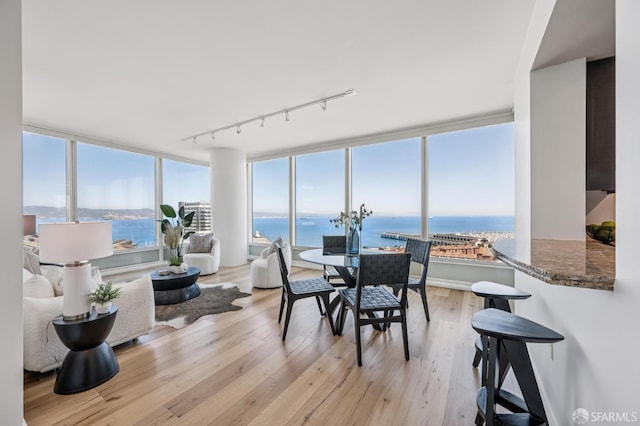 425 1st St Unit 1402, San Francisco, CA 94105 - dining space featuring rail lighting, a water view, light wood-style flooring, and a wall of windows