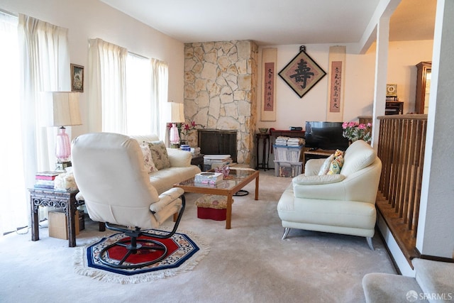 living room with a stone fireplace and light colored carpet