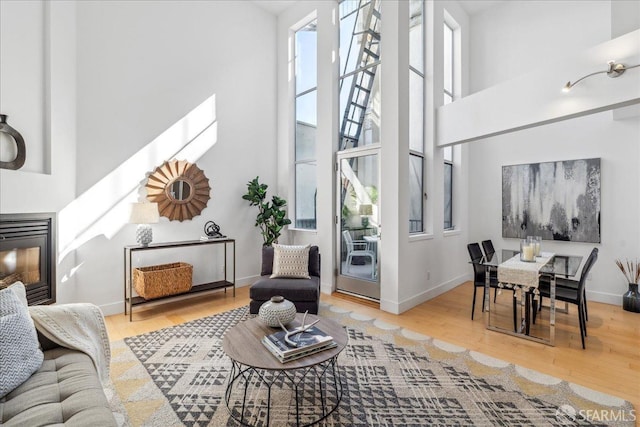 living room with a towering ceiling and hardwood / wood-style floors