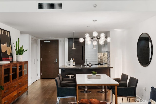 420 Mission Bay Blvd Unit 311, San Francisco, CA 94158 - kitchen with dark wood-style flooring, tasteful backsplash, a chandelier, decorative light fixtures, and an island with sink