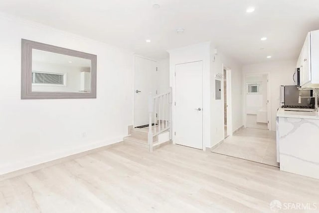 unfurnished room with light wood-type flooring, baseboards, visible vents, and recessed lighting