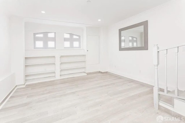 unfurnished room featuring ornamental molding, wood finished floors, and baseboards