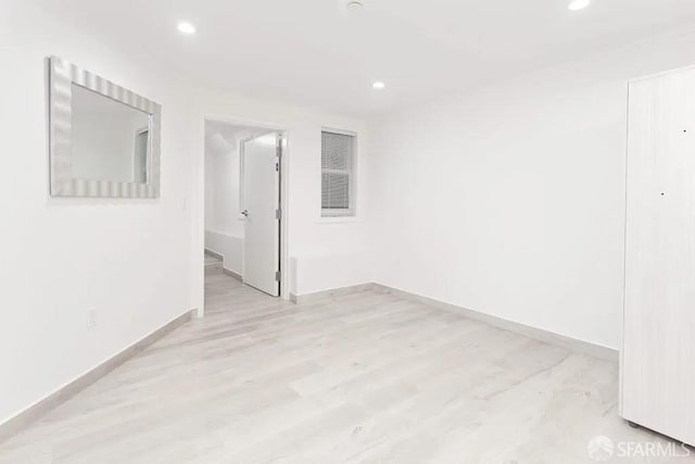 unfurnished room featuring light wood-type flooring, recessed lighting, and baseboards