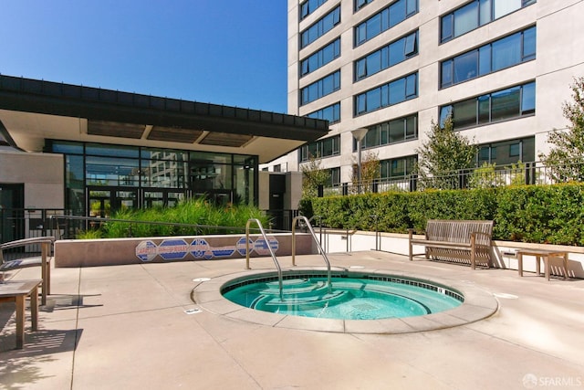 view of pool with a community hot tub and fence