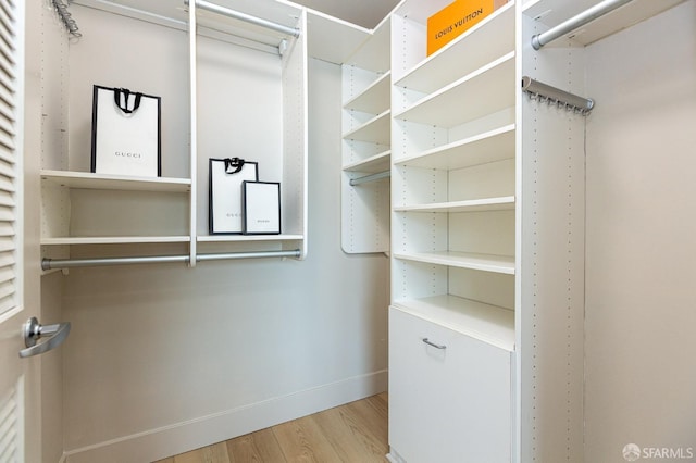 walk in closet with wood finished floors