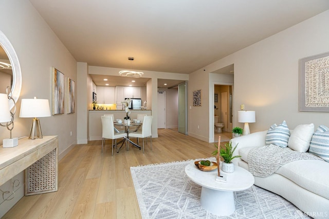 living area with light wood finished floors, recessed lighting, and baseboards