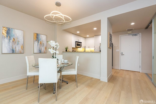 dining area featuring a notable chandelier, recessed lighting, visible vents, light wood-style floors, and baseboards