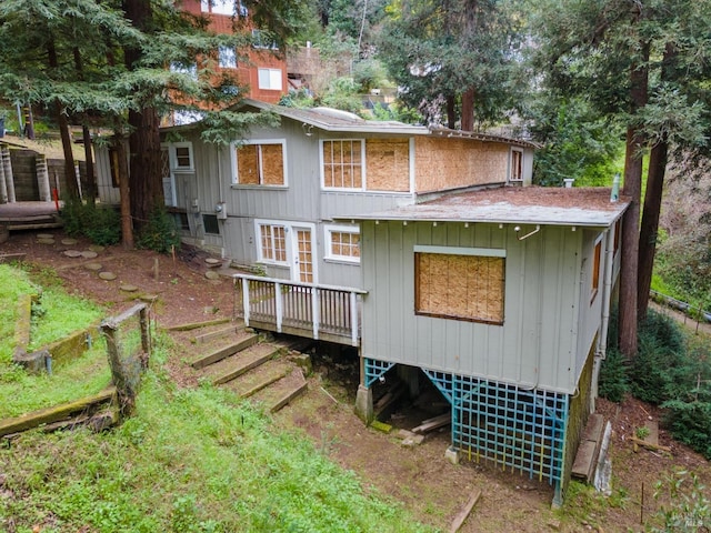 rear view of property featuring a wooden deck