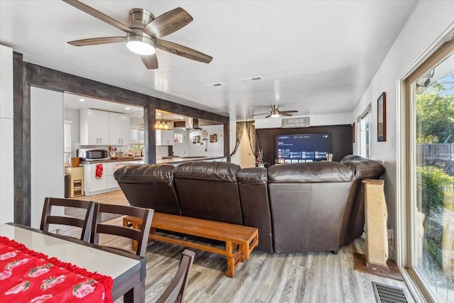 living room with light wood-type flooring and ceiling fan