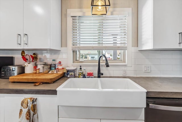 kitchen with sink, white cabinetry, stainless steel dishwasher, and tasteful backsplash