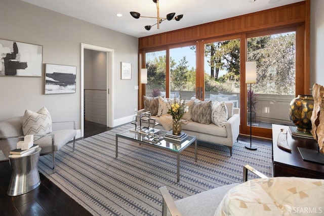 living area featuring a notable chandelier, recessed lighting, dark wood-type flooring, and baseboards