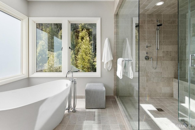 bathroom featuring tile patterned flooring, recessed lighting, a shower stall, and a freestanding bath