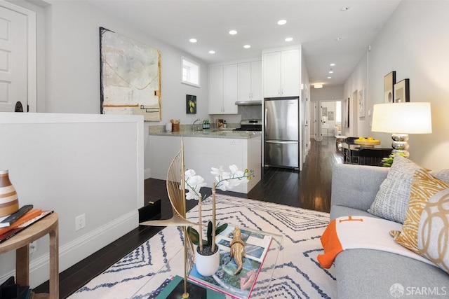 living room with recessed lighting, baseboards, and dark wood-type flooring