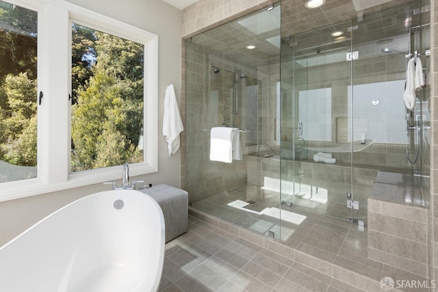 bathroom featuring recessed lighting, a freestanding bath, and a shower stall