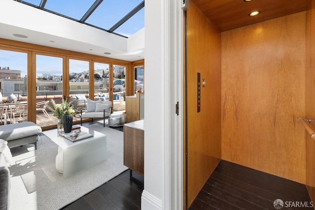 interior space with a skylight, elevator, recessed lighting, and dark wood-style flooring