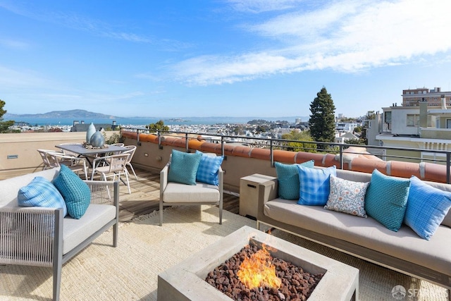 view of patio / terrace with an outdoor living space with a fire pit and a balcony