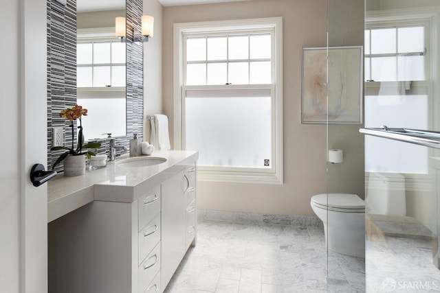 bathroom with toilet, a healthy amount of sunlight, and vanity