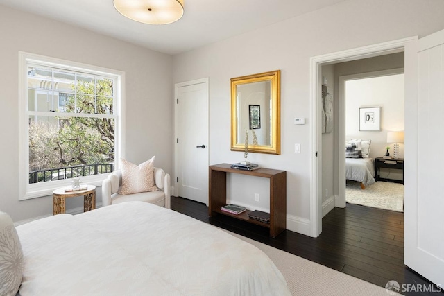 bedroom featuring baseboards and dark wood-type flooring