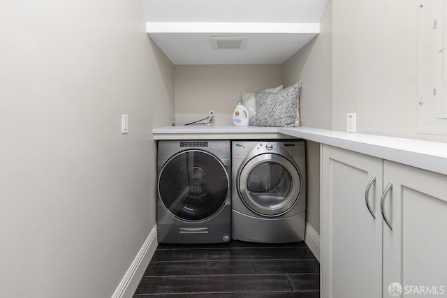 laundry room featuring visible vents, baseboards, laundry area, independent washer and dryer, and dark wood-style flooring