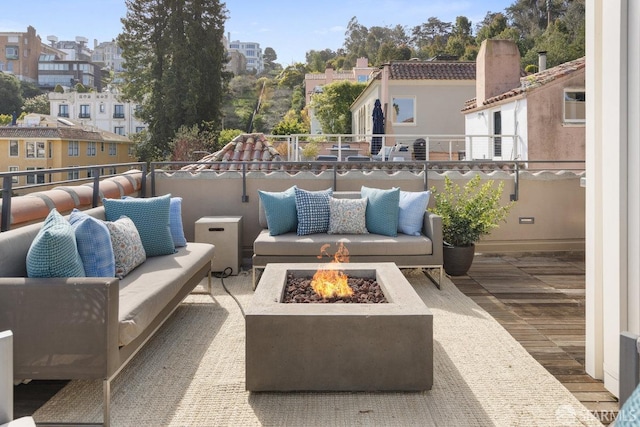 view of patio / terrace with an outdoor living space with a fire pit and a balcony