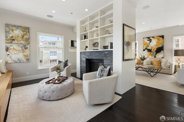 living room featuring recessed lighting, baseboards, hardwood / wood-style floors, and a fireplace