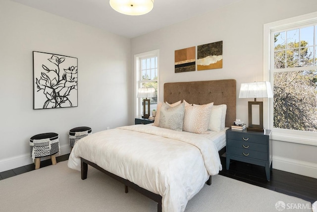 bedroom featuring baseboards and wood finished floors