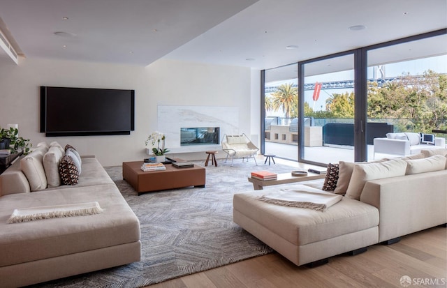 living room with a wall of windows and wood finished floors