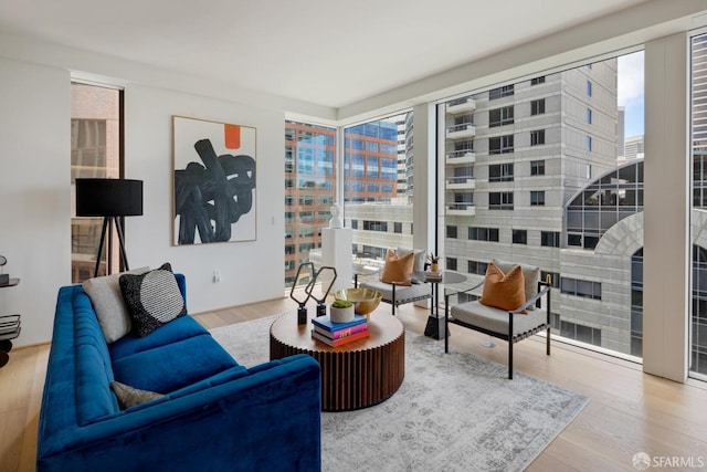 living room with a view of city, wood finished floors, and a wealth of natural light