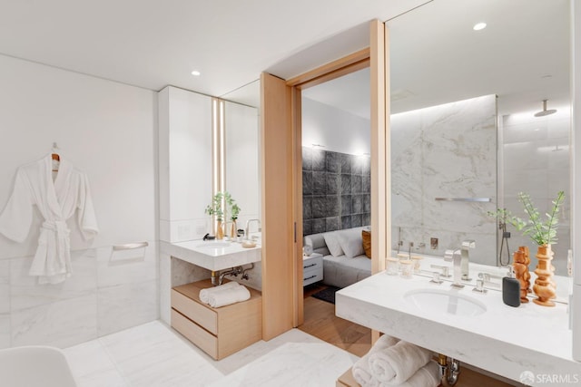 full bath with recessed lighting, a sink, tile walls, and walk in shower