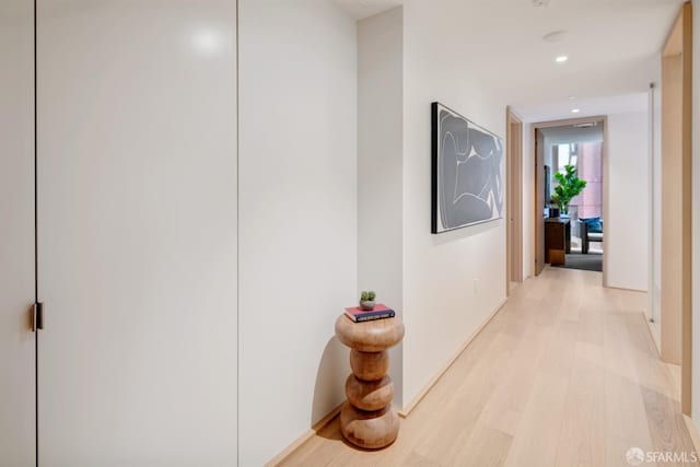 hallway featuring light wood-type flooring and recessed lighting