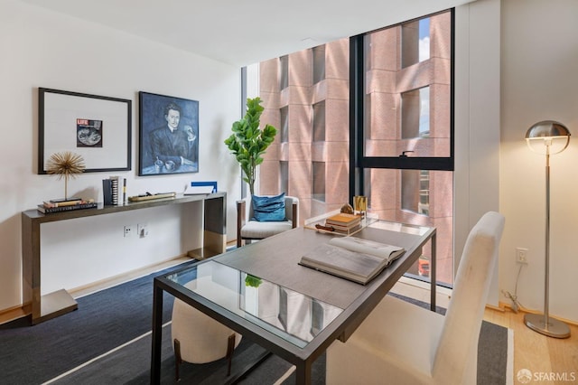 dining space featuring a wall of windows and wood finished floors