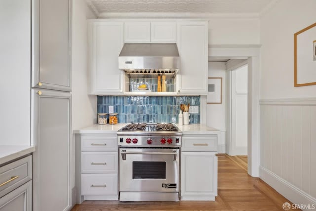 1383 8th Ave, San Francisco, CA 94122 - kitchen with premium stove, wall chimney exhaust hood, light countertops, backsplash, and crown molding