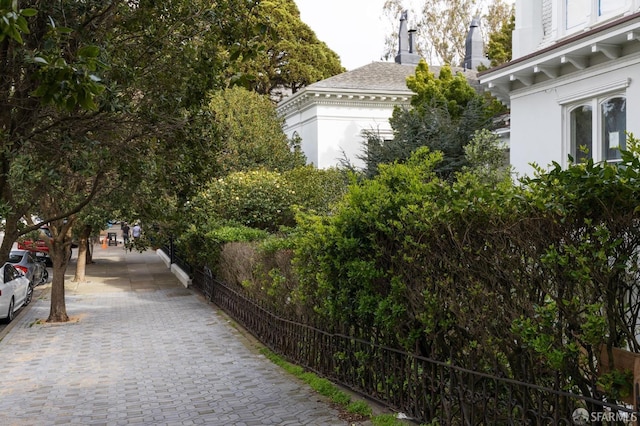 view of side of home featuring fence and stucco siding