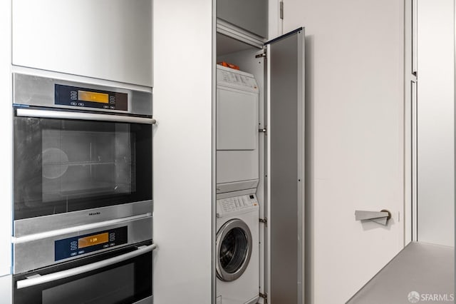 clothes washing area with laundry area and stacked washing maching and dryer