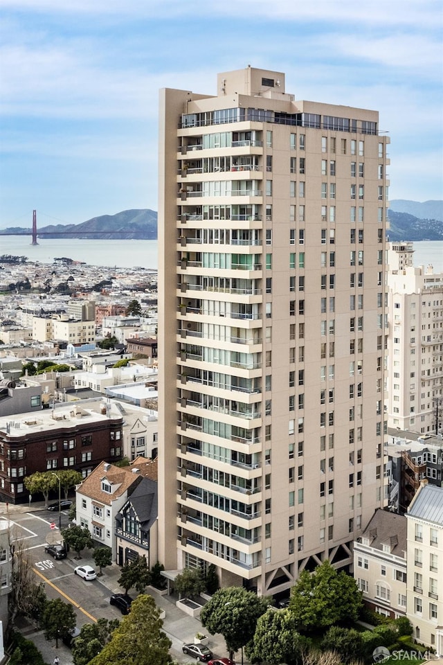 view of building exterior featuring a water and mountain view and a city view