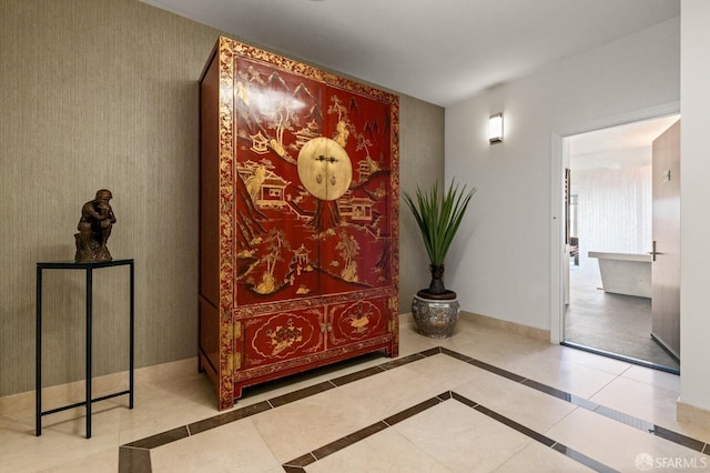 hallway featuring tile patterned floors and baseboards