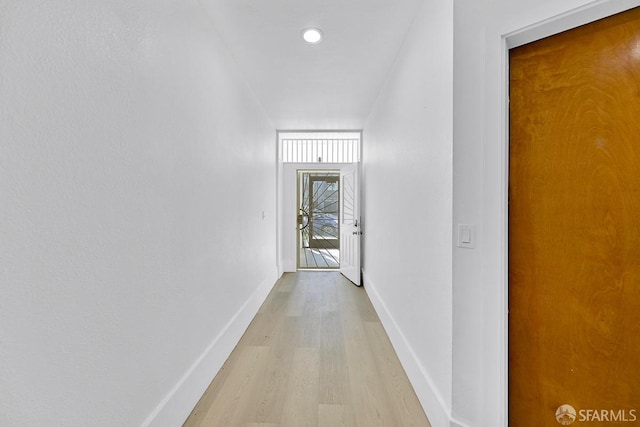 corridor featuring light wood-style floors and baseboards