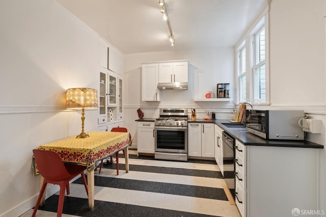 kitchen featuring stainless steel appliances, rail lighting, sink, and white cabinets