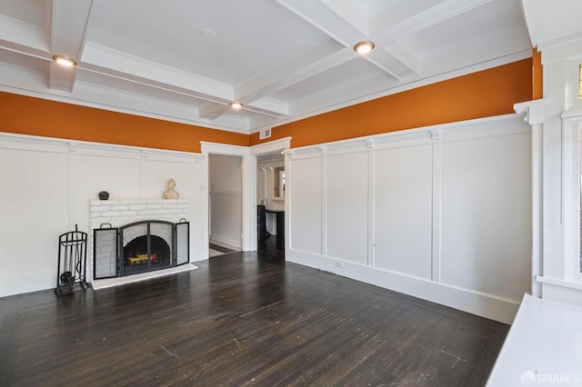 living room with beamed ceiling, coffered ceiling, dark hardwood / wood-style flooring, and a brick fireplace