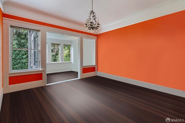 unfurnished room featuring crown molding, dark wood-type flooring, and a notable chandelier